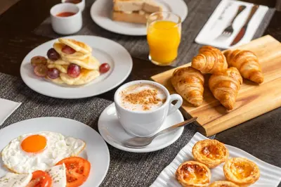 a table with plates of breakfast foods and a cup of coffee at HF Fénix Porto in Porto