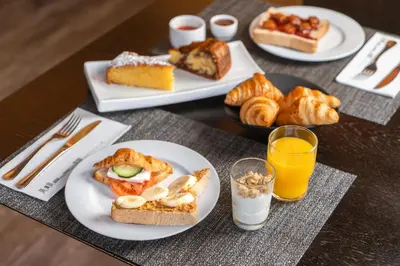 a table with plates of pastries and glasses of orange juice at HF Fénix Porto in Porto