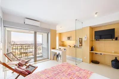 a room with a bed and a kitchen with a balcony at CM Antas Studios in Porto