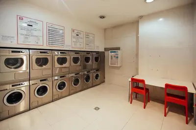 a laundry room with a row of washers and dryers at CM Antas Studios in Porto