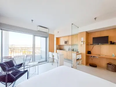 a bedroom with a bed and a kitchen with a balcony at CM Antas Studios in Porto