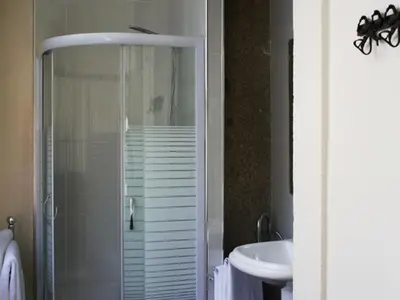 a bathroom with a glass shower and a sink at Pedra Iberica in Porto