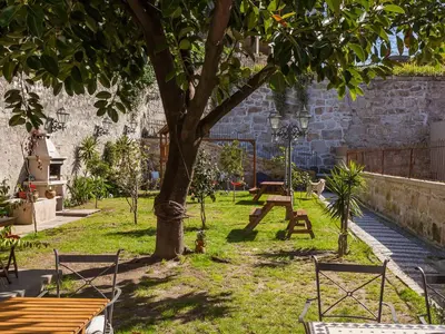 a park with a tree and a table and chairs at Pedra Iberica in Porto
