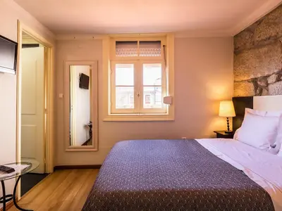a bedroom with a large bed and a window at Pedra Iberica in Porto