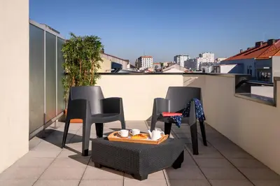a balcony with chairs and a tray of food on it at TRYP by Wyndham Porto Centro Hotel in Porto