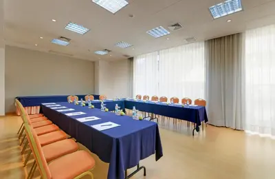 a conference room with blue tables and chairs and windows at TRYP by Wyndham Porto Centro Hotel in Porto
