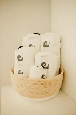 a basket filled with white towels on a wall at H.ö.H in Porto