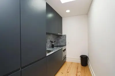 a kitchen with gray cabinets and a wooden floor at Oporto Cool - Fontainhas in Porto