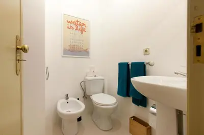a white bathroom with a toilet and a sink at Cozy Apartment Casa da Música in Porto