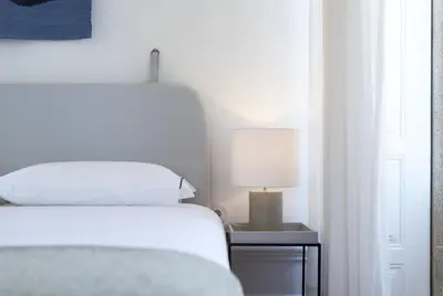 a bedroom with a bed and a table with a lamp at Tripas-Coração, São Bento Apartments in Porto