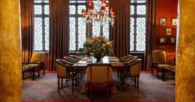 a dining room with a table and chairs and a chandelier at Grande Hotel do Porto in Porto