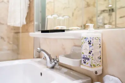 a bottle of toothpaste sitting on a sink in a bathroom at Grande Hotel do Porto in Porto