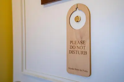a door sign that reads please do not disturb at Grande Hotel do Porto in Porto