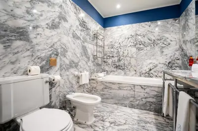 a bathroom with a white toilet and a bath tub at Grande Hotel do Porto in Porto