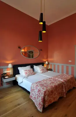 a bedroom with a large bed with red walls at Grande Hotel do Porto in Porto