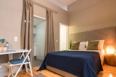 a bedroom with a bed and a desk and a table at bnapartments Rio in Porto
