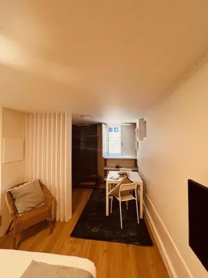 a small room with a small table and a kitchen at bnapartments Rio in Porto