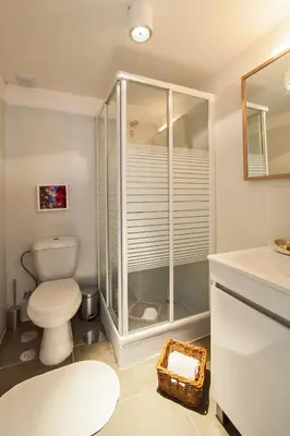 a bathroom with a toilet and a glass shower at bnapartments Rio in Porto