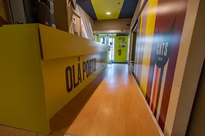 a hallway in a store with a sign on the wall at CATS Porto Hostel in Porto