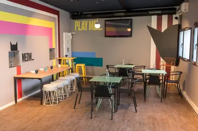 a restaurant with tables and chairs in a room at CATS Porto Hostel in Porto