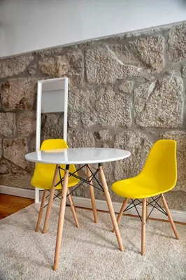 a table and two chairs in front of a stone wall at Try Oporto - Ribeira in Porto