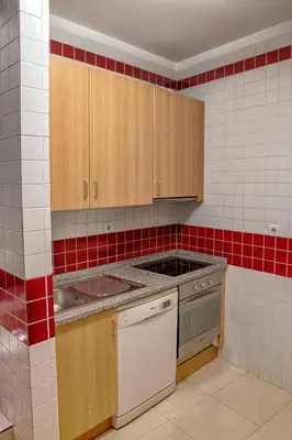 a kitchen with wooden cabinets and a stove at Try Oporto - Ribeira in Porto