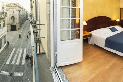 a hotel room with a bed and a view of a street at Hotel Internacional Porto in Porto