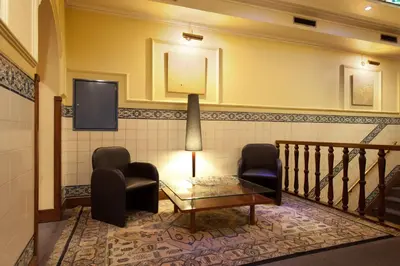 a waiting room with two chairs and a table and a tv at Hotel Internacional Porto in Porto