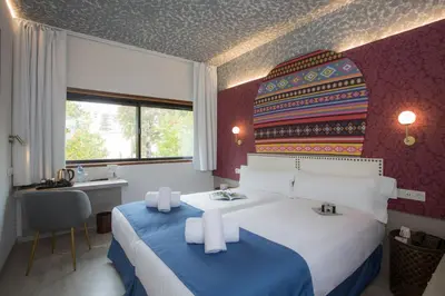 a hotel room with a bed and a desk and a window at Casual Inca Porto in Porto