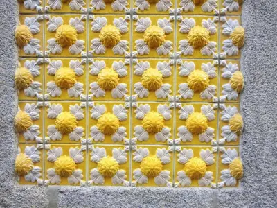 a metal wall with yellow and white flowers on it at Oporto Delight 1 Luxury Apartment in Historic Center with Balcony Max 4 p in Porto
