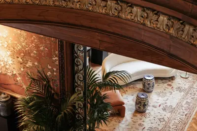 a mirror in a room with a table and a plant at Infante Sagres - Small Luxury Hotels Of The World in Porto