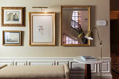 a living room with a couch and a table and mirrors at Infante Sagres - Small Luxury Hotels Of The World in Porto