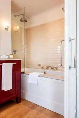 a bathroom with a tub and a glass shower at Infante Sagres - Small Luxury Hotels Of The World in Porto