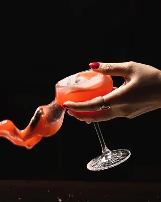 a woman holding a glass filled with red liquid at Infante Sagres - Small Luxury Hotels Of The World in Porto