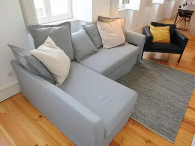 a gray couch with pillows on it in a living room at Oporto Delight 3 Luxury Apartment in Historic Center Max 4p in Porto