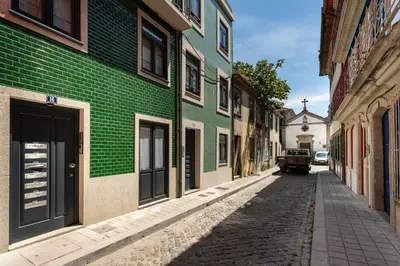 an alley with a green building and a truck parked on a street at Janika's Patio in Porto
