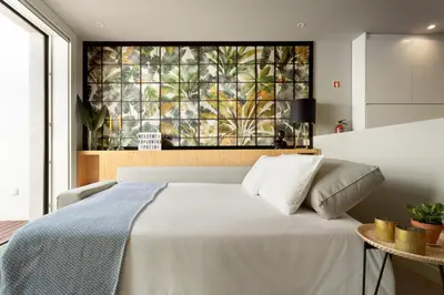 a bedroom with a bed with a painting on the wall at Janika's Patio in Porto