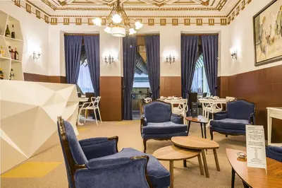 a waiting room with blue chairs and tables and windows at Costa do Sol B&B in Porto