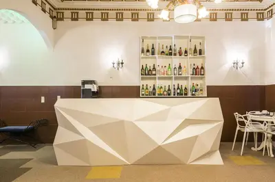 a large white table in a room with a shelf of wine bottles at Costa do Sol B&B in Porto