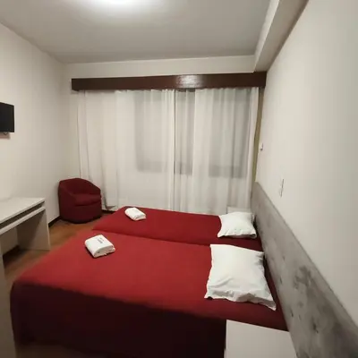 a bedroom with a red bed and a chair at Hotel S. Gabriel in Porto