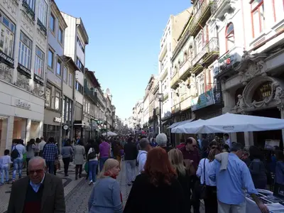 a crowd of people walking down a street with buildings at Hotel S. Gabriel in Porto