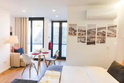 a bedroom with a bed and a table with chairs at APOSENTUS - Your Home at Pinheiro's Studio in Porto