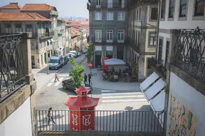 a red fire hydrant on a city street with buildings at APOSENTUS - Your Home at Pinheiro's Studio in Porto