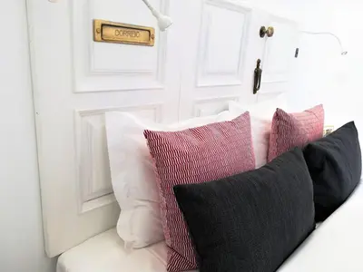 a group of pillows sitting on a white couch at APOSENTUS - Your Home at Pinheiro's Studio in Porto