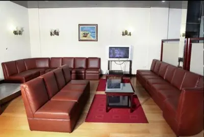 a living room with brown leather couches and a tv at Hotel Palanca in Porto