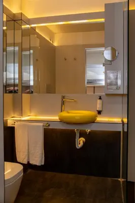a bathroom with a yellow sink and a mirror at WOT Porto Soul in Porto
