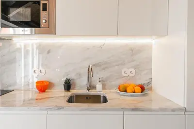 a kitchen with a sink and a bowl of oranges at Indulge Porto Flats in Porto