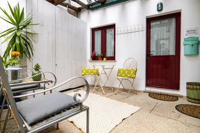a patio with chairs and a table and a red door at Red House 2- With terrace in Porto