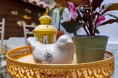 a table with a bird figurine and flowers on it at Red House 2- With terrace in Porto