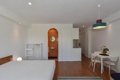 a room with a bed and a table and a kitchen at Porto Republica Flat in Porto